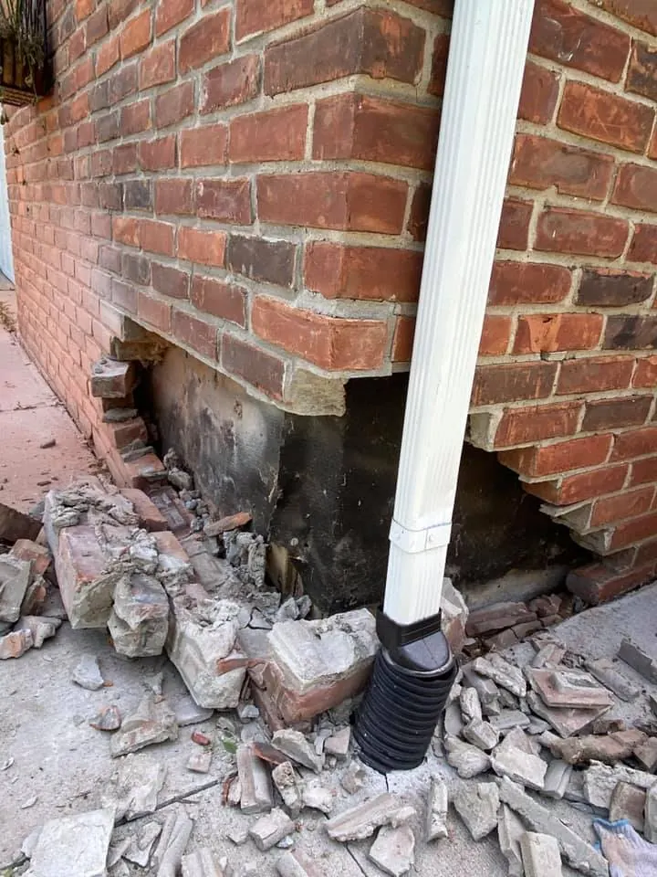 Before: brick corner repair at the downspout job before work started