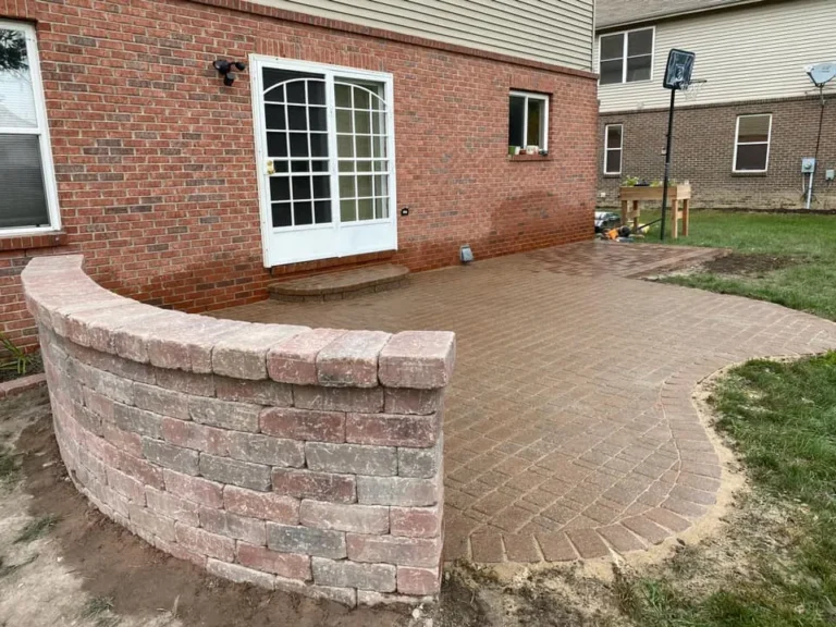 Brick patio with curved seat wall, completed by It's The Brick Guys in Metro Detroit