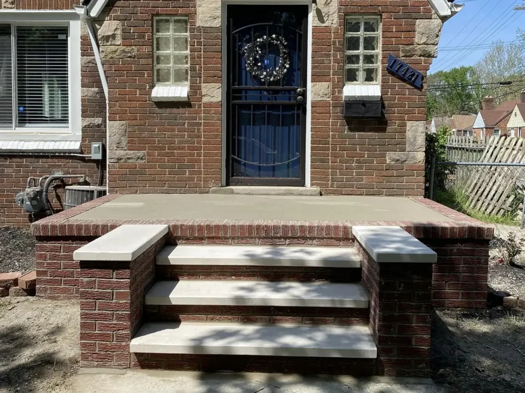 Rebuilt red brick porch and stone-capped steps on a brick home