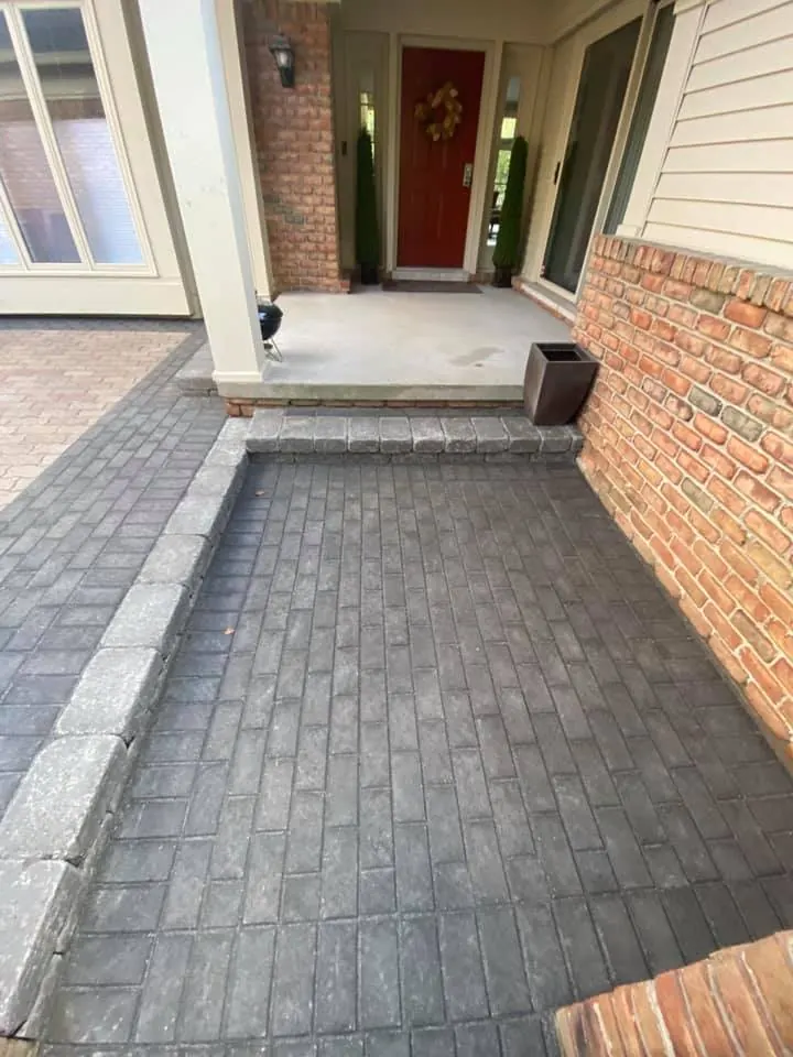 Courtyard paver patio with gray border, completed by It's The Brick Guys in Metro Detroit