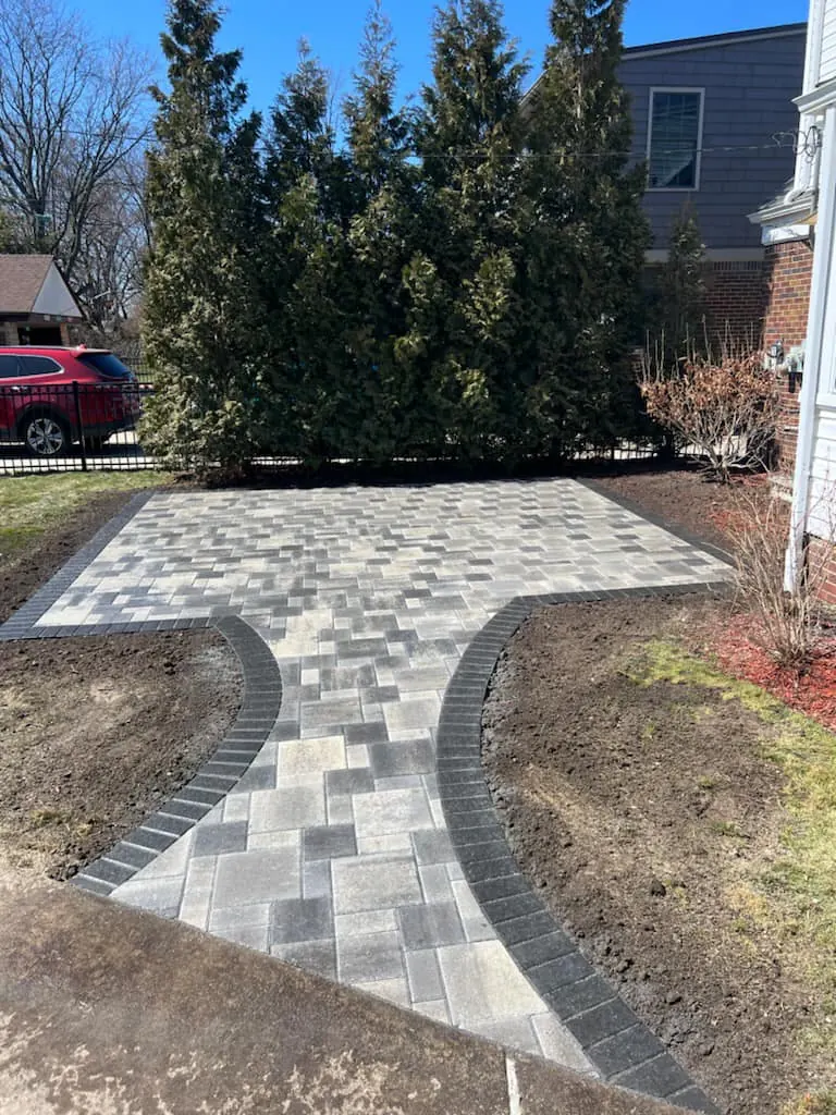 Gray paver patio on a bare lawn, completed by It's The Brick Guys in Metro Detroit (view 2)