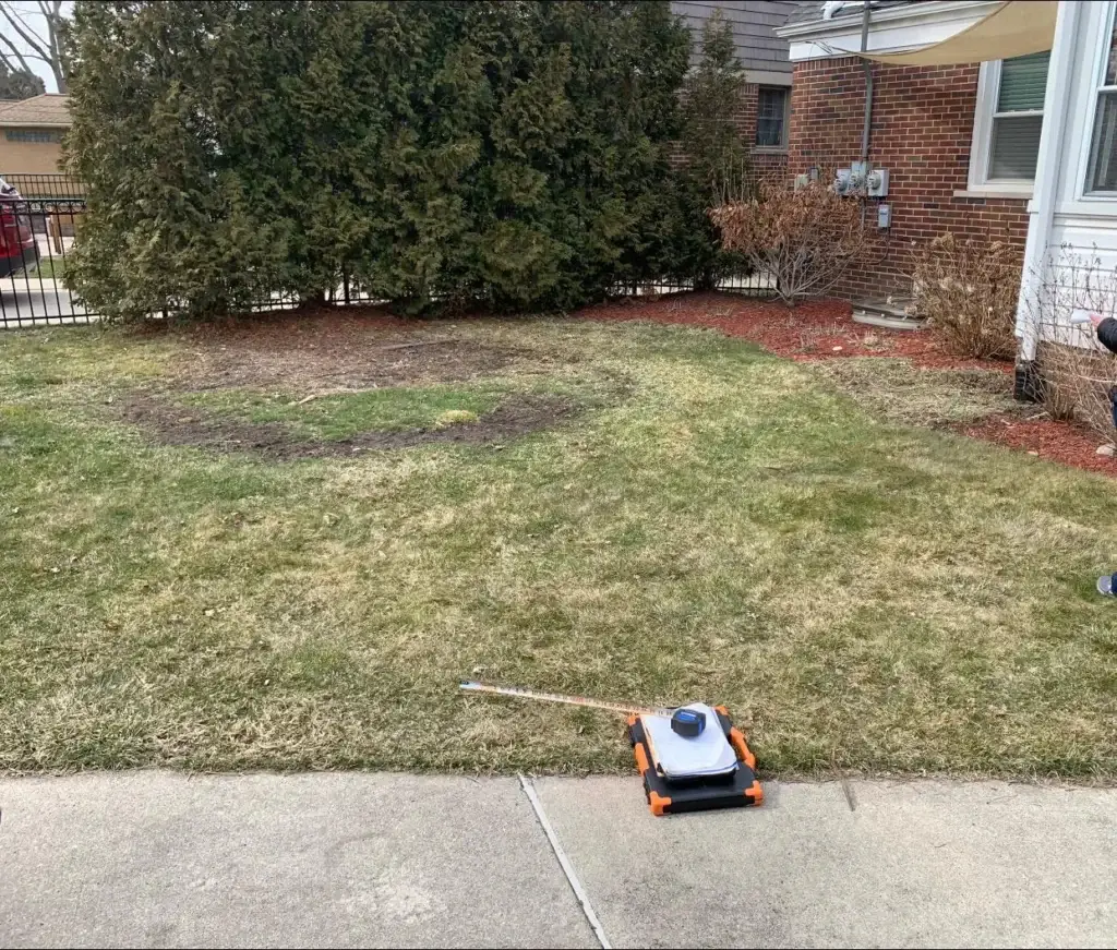 Before: gray paver patio on a bare lawn job before work started