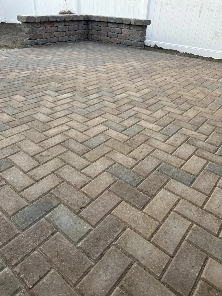Herringbone paver patio with seat wall, completed by It's The Brick Guys in Detroit, MI