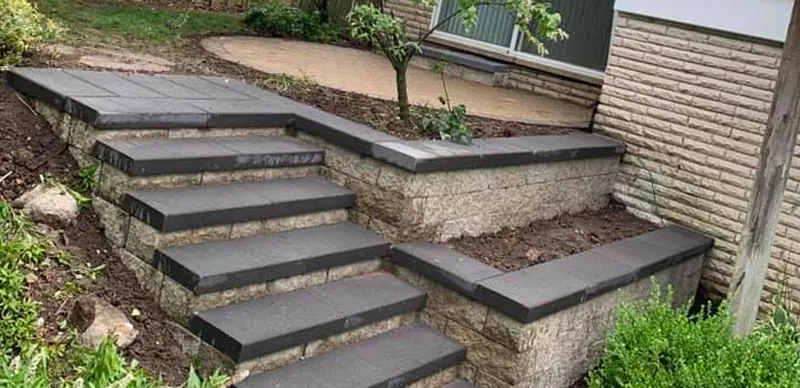New paver steps with stone retaining walls and charcoal caps