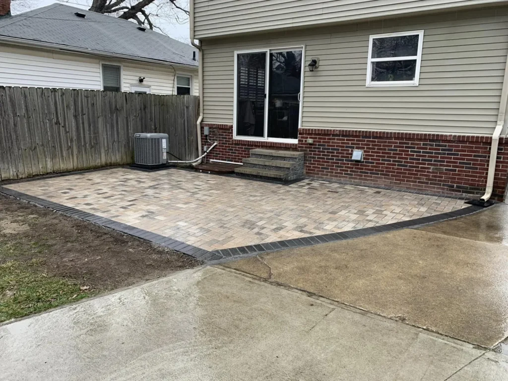 Raised paver patio with seat wall and steps, completed by It's The Brick Guys in Metro Detroit