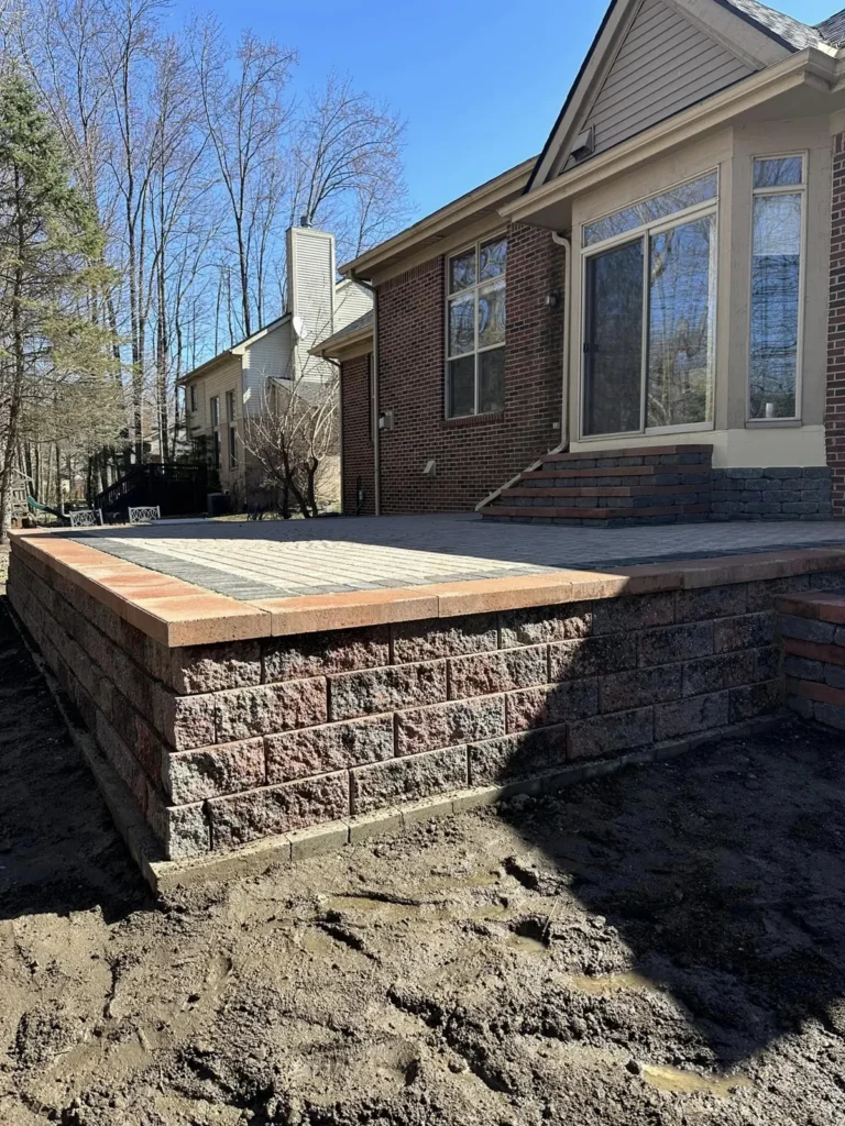 Raised paver patio with seat wall and steps, completed by It's The Brick Guys in Metro Detroit (view 2)