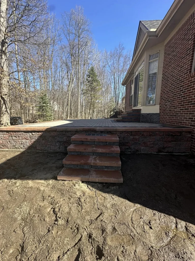 Raised paver patio with seat wall and steps, completed by It's The Brick Guys in Metro Detroit (view 4)