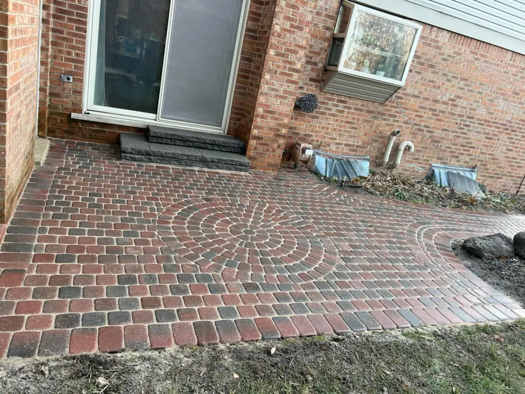 Red brick patio with circle pattern and walkway, completed by It's The Brick Guys in Metro Detroit